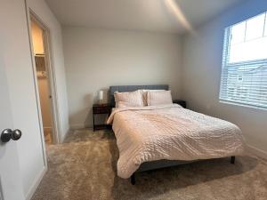 Un dormitorio con una cama grande con ventana. en A modern retreat and Gateway to Yosemite, en Merced