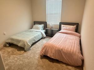 Un dormitorio con dos camas y una ventana. en A modern retreat and Gateway to Yosemite, en Merced