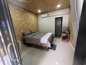 a bedroom with a bed and a tv in it at Grand Bungalow in Ban Ting Rai
