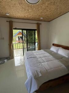 una camera da letto con un letto grande e un balcone di Grand Bungalow a Ban Ting Rai