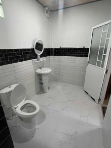 un bagno bianco con un water e un lavandino di Grand Bungalow a Ban Ting Rai