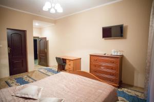 a bedroom with a bed and a dresser and a tv at V&P HOTEL & Restaurant in Khust