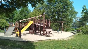 a wooden playground with a slide and a slideintend at Ferienwohnungen Goller in Großkoschen
