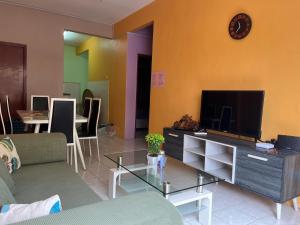 a living room with a couch and a tv at Kelly Cozy cottage in Kampar