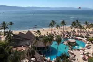 a view of a resort with a pool and a beach at LXHotel Condomar in Puerto Vallarta