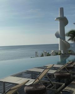 a swimming pool with chairs and a view of the ocean at Trogon's Perch in San Isidro