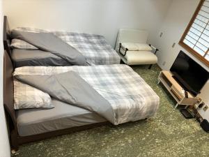 En eller flere senge i et værelse på 伊東駅前ゲストハウス