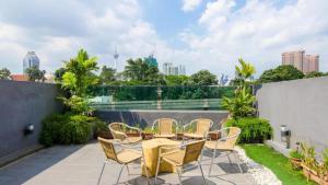 a patio with a table and chairs on a balcony at i-Hotel Kuala Lumpur in Kuala Lumpur