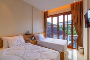 Ngurah Rai International AirportにあるAA Inn Kuta Beachのベッドが2つと大きな窓があるホテルの部屋