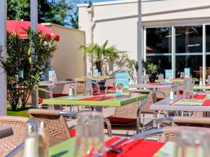a group of tables and chairs in a restaurant at ibis Lyon Est Bron in Bron