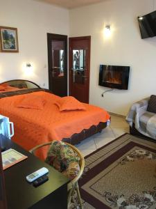 a bedroom with a bed with an orange comforter at Guesthouse Elizabeth in Samokov +35 photos