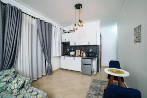 a living room with a couch and a table and a kitchen at Lavista Place in Jinja