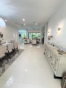a living room with white tile floors and a dining room at Tropical Oasis in Naples