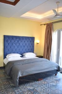 Un dormitorio con una cama grande con cabecero azul. en Casa de joana deluxe, en Calangute