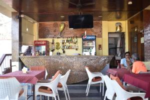a restaurant with a bar with people sitting at tables at Casa de joana deluxe in Calangute
