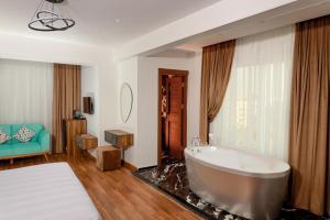 Un baño con una bañera grande en una habitación. en New LA Veranda Pyramids Inn, en El Cairo