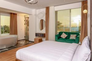 1 dormitorio con cama, bañera y sofá verde en New LA Veranda Pyramids Inn, en El Cairo