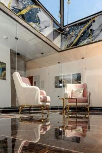 Dos sillas y una mesa en una habitación. en New LA Veranda Pyramids Inn, en El Cairo