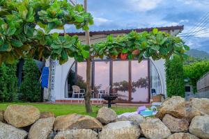 une maison avec un arbre et des rochers dans la cour dans l'établissement Serenity Sands Villa, Beachfront and Mountain View, à Chaloklum