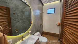 La salle de bains est pourvue d'un miroir, de toilettes et d'un lavabo. dans l'établissement Serenity Sands Villa, Beachfront and Mountain View, à Chaloklum 26 autres photos
