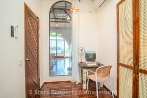 une pièce avec un bureau et un ordinateur sur une table dans l'établissement Serenity Sands Villa, Beachfront and Mountain View, à Chaloklum