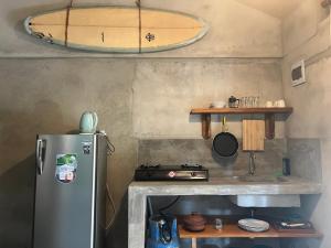 een keuken met een koelkast en een surfplank aan de muur bij Into The Blue - Beach House in Unakuruwa
