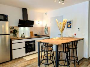 a kitchen with a wooden table and stools at La Parent-aise in Thionville