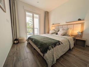 a bedroom with a bed and a large window at La Parent-aise in Thionville
