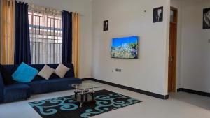 een woonkamer met een blauwe bank en een tafel bij Dans place in Moshi