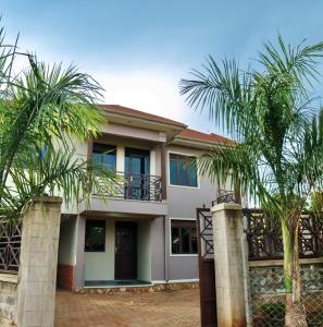 a house with palm trees in front of it at Lavista Place in Jinja
