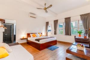 una camera da letto con un letto e un ventilatore a soffitto di Emeraldgems Premium Residence a Phnom Penh