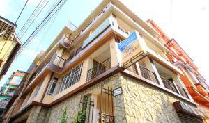 Un edificio con un cartel al costado. en The Broadway- Annecy Inn Near Mall Road with -Wi-Fi -Restaurant -Premium &amp; Deluxe Rooms Prime Location - Best Top Rated Hotel In Darjeeling, en Darjeeling