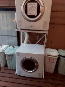 Una lavadora en un soporte con dos botes de basura en Prosper 6th bldg, en Nagoya