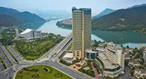 an aerial view of a tall building next to a river at Jiande Peninsula Kaihao Hotel in Thousand Island Lake