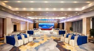 a large banquet hall with blue tables and white chairs at Jiande Peninsula Kaihao Hotel in Thousand Island Lake