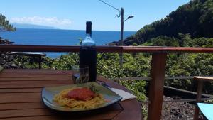 un plato de pasta y una botella de vino en una mesa en Adega dos Terceira, en Baía de Canas