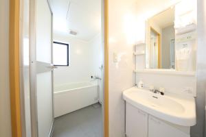 Un baño blanco con lavabo y espejo. en Prosper 6th bldg, en Nagoya 20 fotos más