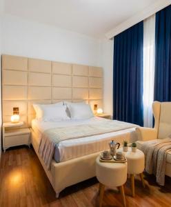 a bedroom with a large bed and a couch at City Urban Hotel in Tirana