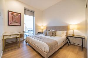 une chambre avec un grand lit et une grande fenêtre dans l'établissement Marbella Lane - Luxury Beachside 2BR, à Long Beach