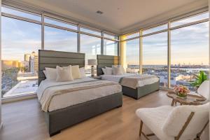 - 2 lits dans une chambre avec de grandes fenêtres dans l'établissement Marbella Lane - Luxury Beachside 2BR, à Long Beach