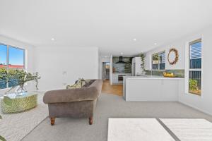 カイコウラにあるOcean Vista Hideawayのリビングルーム(椅子付)、キッチン +4枚の写真