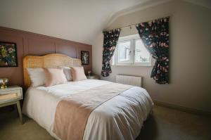 una camera da letto con un letto grande e una finestra di Daisy Cottage - Framlingham a Framlingham