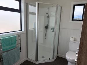 a shower stall in a bathroom with a toilet at Just Dean Motueka in Lower Moutere