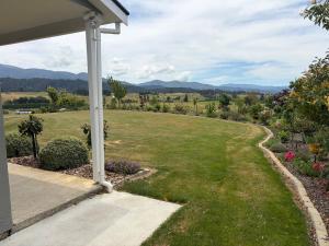 a view from the porch of a house with a lawn at Just Dean Motueka in Lower Moutere +6 photos
