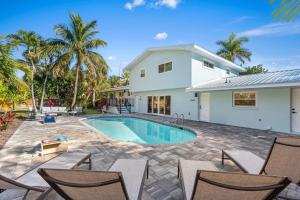 una casa con piscina e sedie di 502 Colony Street a Melbourne Beach