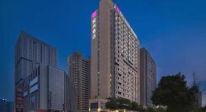 Echarm Hotel Changsha High-speed Railway Station في تشانغشا: مبنى مرتفع مع لافتة في أعلاه