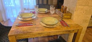 a wooden table with plates and wine glasses on it at Amore Grande in Samokov +4 photos