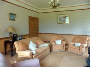 a living room with a couch and two chairs at Littlebridge House in Bromyard