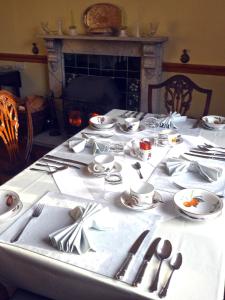 una mesa con platos y utensilios encima en Littlebridge House, en Bromyard