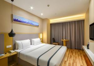 City Comfort Inn Jingzhou Hongxing Road Food Street في Shashi: غرفة فندقية مع سرير كبير وتلفزيون
